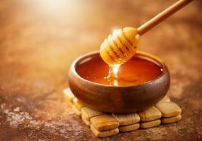 Honey,Dripping,From,Honey,Dipper,In,Wooden,Bowl.,Close-up.,Healthy