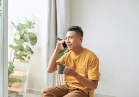 man on phone drinking tea